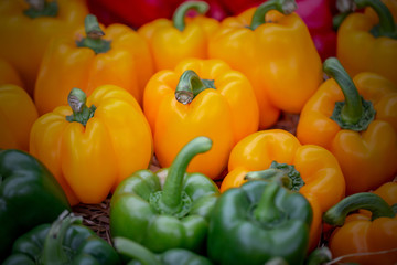 The fresh bell peppers on the husk or hay in good natural light. 