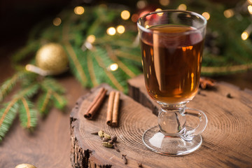Spiced Apple Cider Mulled Sangria in glass cup on wooden background. Hot drinks for Christmas.