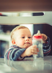 Fototapeta premium Little baby holding his bottle