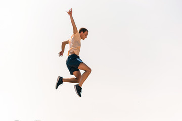 Fototapeta na wymiar Fitness parkour man training jumping in skatepark