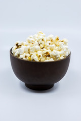 Popcorn in wooden bowl isolated on white background. Selective focus.