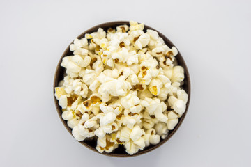 Popcorn in wooden bowl isolated on white background. Top view.Selective focus.