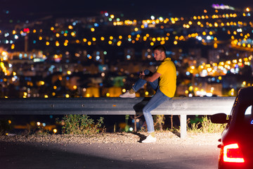 Man looking above the city in the night and thinking about his life.