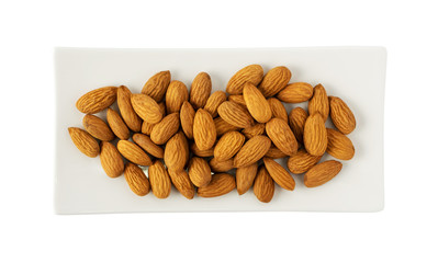 Heap of whole almond nuts on white plate top view