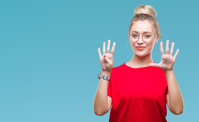 Young blonde woman wearing glasses over isolated background showing and pointing up with fingers...