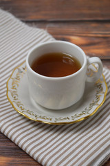 A Cup of fragrant tea on a wooden background.