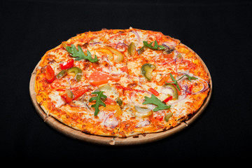 Pizza on a wood board on a black background