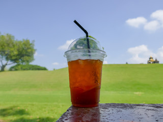 Lemon tea in plastic glass With a lawn background scene