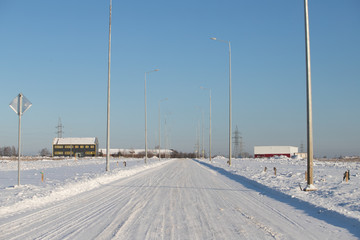 snow covered street road with tire tracks leading through village houses; essex; england; uk