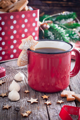 Obraz na płótnie Canvas Red tea mug with cookies in Christmas decorations on a wooden table, selective focus