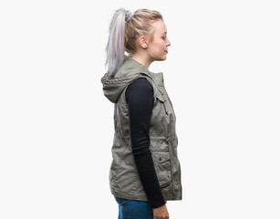 Young blonde woman over isolated background looking to side, relax profile pose with natural face with confident smile.