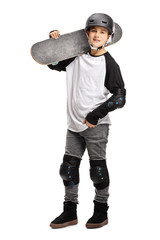Young boy posing with a skateboard on his shoulder and a helmet