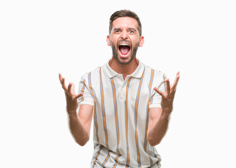 Young handsome man over isolated background crazy and mad shouting and yelling with aggressive expression and arms raised. Frustration concept.