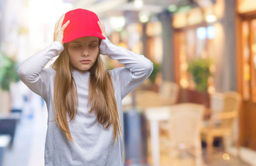 Young beautiful girl wearing red cap isolated background suffering from headache desperate and stressed because pain and migraine. Hands on head.
