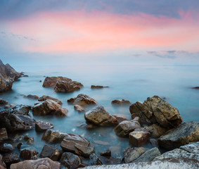 Panele Szklane  spokojne wybrzeże morskie z kamieniami wczesnym rankiem