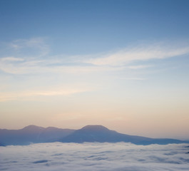 mountain ridge silhouette on a dense cloudy sky background