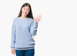 Young Chinese woman over isolated background showing and pointing up with fingers number five while smiling confident and happy.