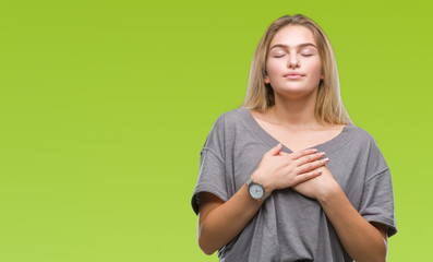 Young caucasian woman over isolated background smiling with hands on chest with closed eyes and grateful gesture on face. Health concept.