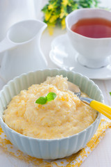 Milk corn porridge in a blue bowl for breakfast, selective focus