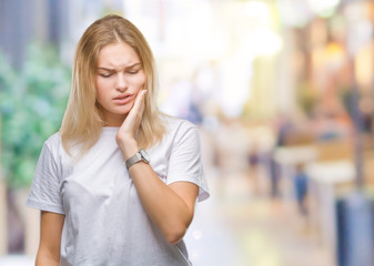 Fototapeta premium Young caucasian woman over isolated background touching mouth with hand with painful expression because of toothache or dental illness on teeth. Dentist concept.