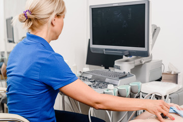 Female doctor using ultrasound machine to make test for patient