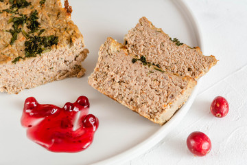 Chicken and liver pate with cranberry sauce, served on plate.