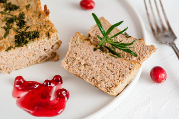 Chicken and liver pate with cranberry sauce, served on plate.