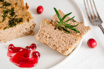 Chicken and liver pate with cranberry sauce, served on plate.