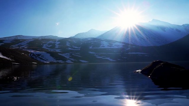 Sunset and sun star and reflection in the lagoon of the moon and a nice view of the nevado de toluca volcano also called xinantecatl which is rarely this snowy