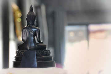 backside of black Buddha with blurred background