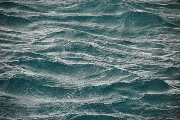 Fototapeta premium Background of abstract flowing waves of ocean in stormy weather. Rough majestic waves of ocean