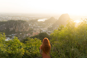 Travel girl with red hair is travelling in Marble Mountains ,staying on the top and watching a view...