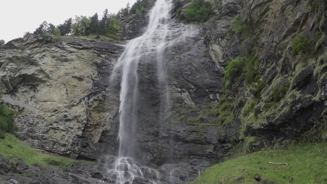 Small but huge waterfall in Austria in Maltatal with rock, green gras and clean weather