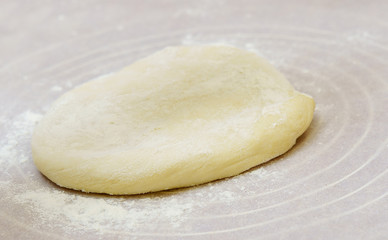 Homemade dough is cut in half on a floured surface.