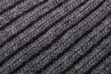 Gray knitted fabric texture close up. Can be used as a background. Selective focus