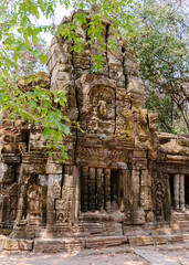 Naklejka premium The temple is partially recovered from the jungle. Many ruins have been reconstructed some remain a jumble of stone with trees growing through the site