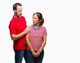 Fototapeta premium Middle age hispanic couple in love over isolated background skeptic and nervous, frowning upset because of problem. Negative person.