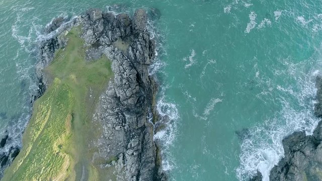 Aerial view of tranquil blue ocean as waves break on weathered limestone rocks in Durness, Scotland