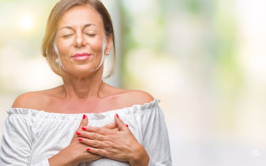 Middle age senior hispanic woman over isolated background smiling with hands on chest with closed eyes and grateful gesture on face. Health concept.