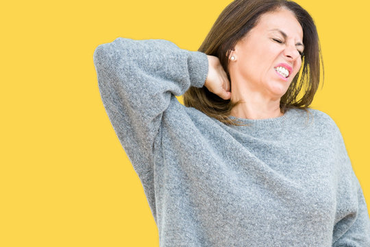 Beautiful middle age woman wearing winter sweater over isolated background Suffering of neck ache injury, touching neck with hand, muscular pain