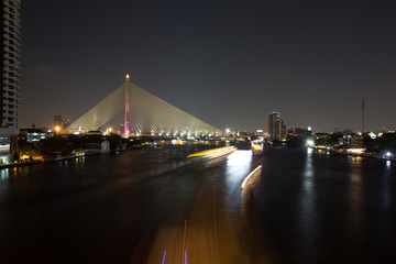 Chao Phraya river at night with illuminated bridge in Bangkok, Thailand