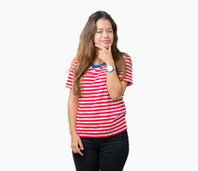 Obraz na płótnie Canvas Young beautiful brunette woman wearing stripes t-shirt over isolated background looking confident at the camera with smile with crossed arms and hand raised on chin. Thinking positive.