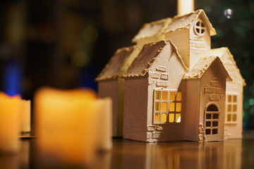 beautiful and emotional decor in the form of a house on the background of warm candles, Christmas decoration and decor