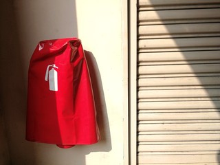 Fire extinguisher in Fire extinguisher cover for Risk area with Sunshine.