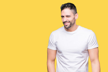 Fototapeta premium Young man wearing casual white t-shirt over isolated background winking looking at the camera with sexy expression, cheerful and happy face.