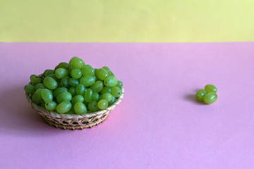 green grape in a bowl on colored background