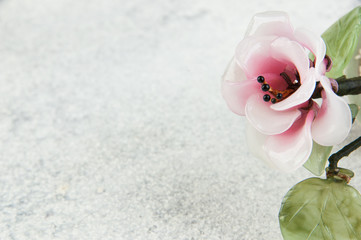 Pink glass flower on concrete background.
