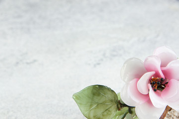 Fototapeta na wymiar Pink glass flower on concrete background.