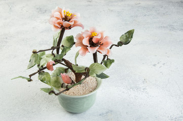 Coral glass flowers on concrete background.