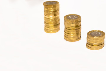 Stacks and Heaps of British GBP Golden Coins Currency Money on white background with empty space